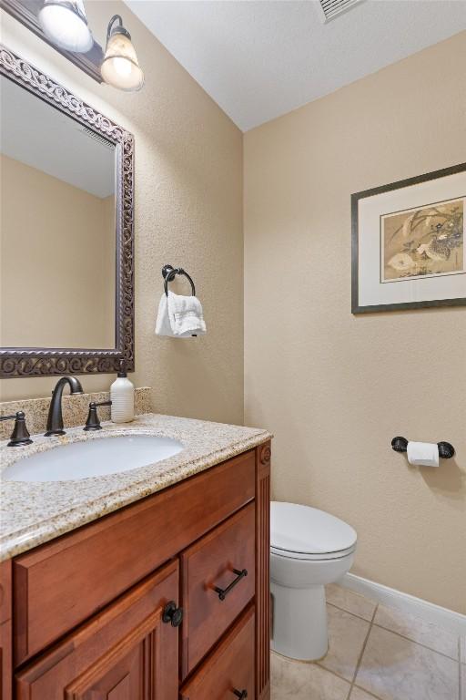 bathroom featuring tile patterned flooring, toilet, and vanity