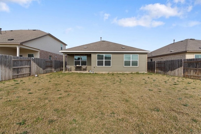 rear view of house with a yard, a patio, and a fenced backyard