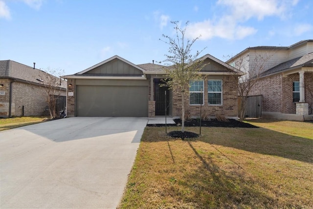 view of front of house featuring a front lawn, a garage, brick siding, and driveway