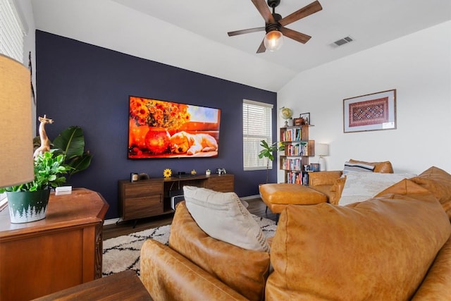 living room featuring lofted ceiling, baseboards, visible vents, and ceiling fan