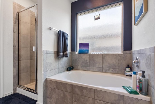 bathroom with a shower stall and a garden tub