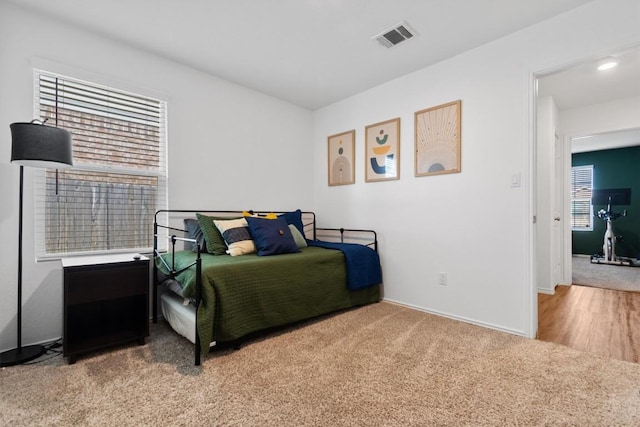 bedroom featuring light colored carpet, visible vents, and baseboards