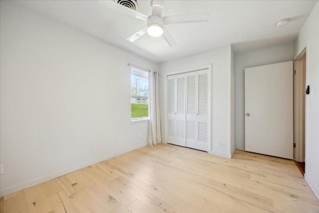 unfurnished bedroom with visible vents, ceiling fan, baseboards, wood finished floors, and a closet