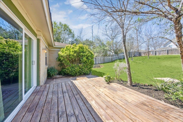 wooden terrace featuring a lawn and a fenced backyard