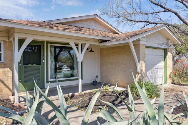 exterior space with brick siding, an attached garage, and driveway