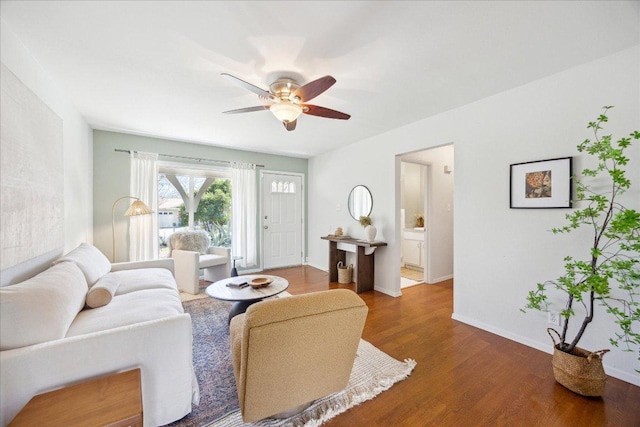 living room with baseboards, ceiling fan, and wood finished floors