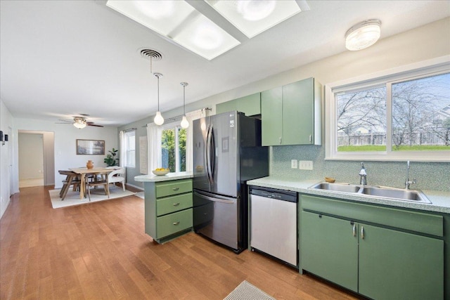 kitchen featuring a sink, appliances with stainless steel finishes, light countertops, and green cabinetry