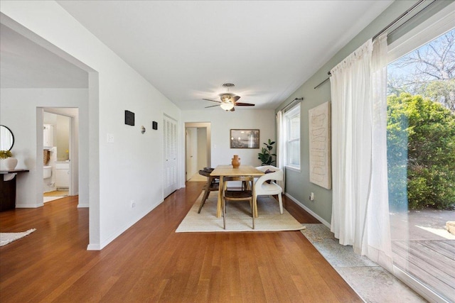 dining area with ceiling fan, baseboards, and wood finished floors