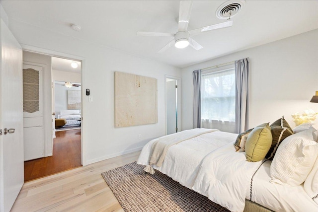 bedroom with visible vents, baseboards, ceiling fan, and light wood finished floors