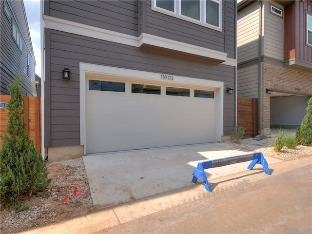 garage with fence and driveway