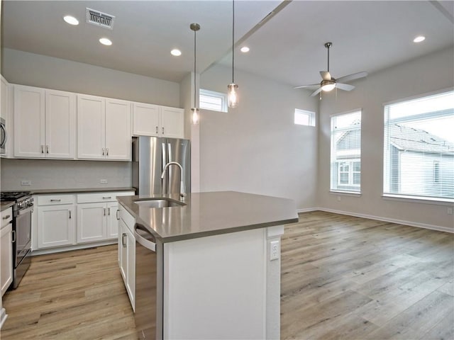 kitchen with visible vents, a sink, dark countertops, appliances with stainless steel finishes, and ceiling fan