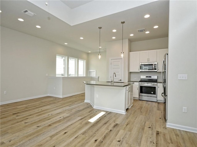 kitchen with visible vents, light wood finished floors, appliances with stainless steel finishes, and white cabinetry