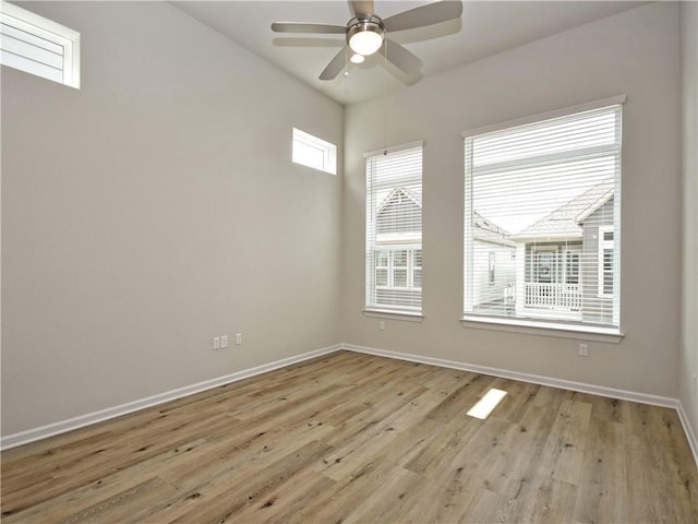 spare room with a ceiling fan, wood finished floors, and baseboards