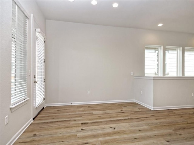 spare room featuring recessed lighting, baseboards, and wood finished floors