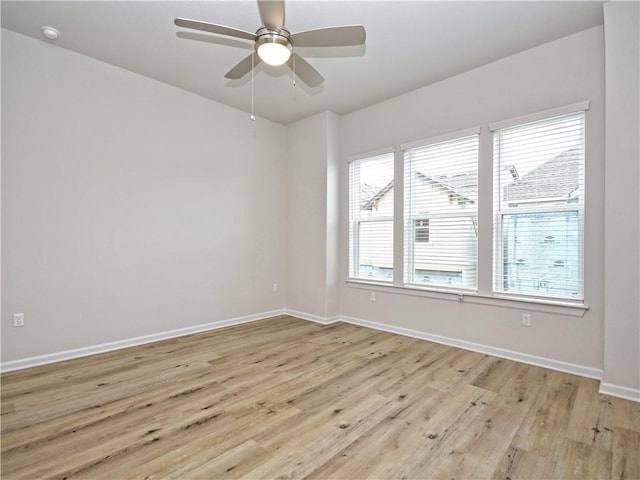 unfurnished room with a ceiling fan, light wood-type flooring, and baseboards