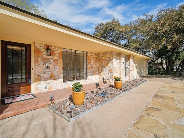 view of patio featuring concrete driveway and an attached garage