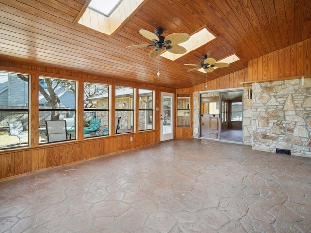 unfurnished sunroom featuring wooden ceiling, vaulted ceiling with skylight, and ceiling fan