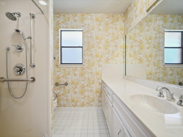 bathroom featuring wallpapered walls, vanity, tile patterned flooring, and a textured ceiling