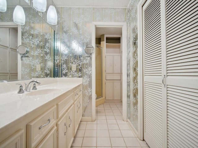 full bath with tile patterned flooring, wallpapered walls, vanity, and baseboards