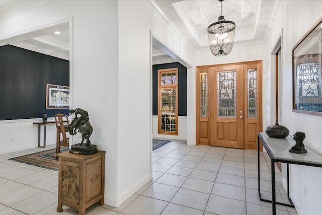 foyer with crown molding, a notable chandelier, baseboards, and light tile patterned floors