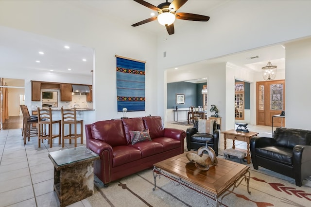 living area with light tile patterned floors, visible vents, recessed lighting, ceiling fan, and a towering ceiling