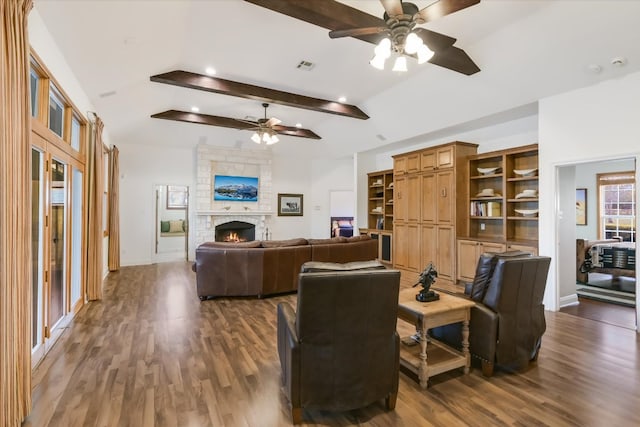 living area with visible vents, a fireplace, a ceiling fan, and dark wood-style flooring