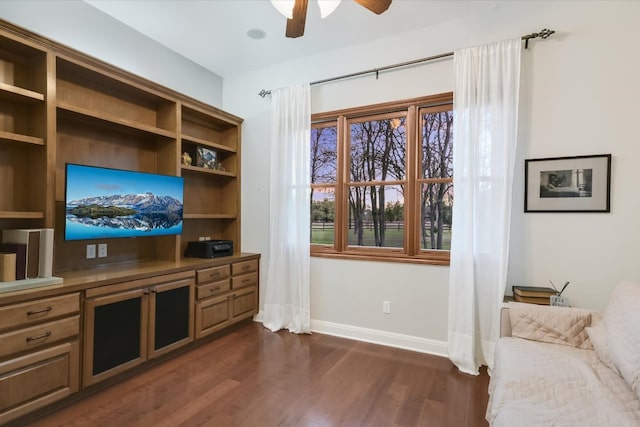 living room with baseboards, ceiling fan, and dark wood-style flooring