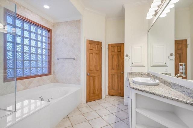 full bath with tile patterned floors, a garden tub, ornamental molding, and vanity