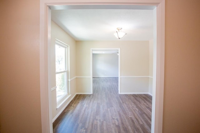 unfurnished room with a wealth of natural light, baseboards, and wood finished floors