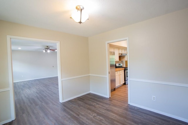 unfurnished room featuring baseboards, dark wood-type flooring, and ceiling fan