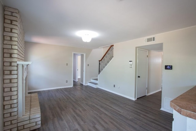 unfurnished living room featuring dark wood-style floors, visible vents, stairs, and baseboards