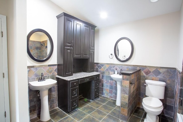 bathroom with tile patterned flooring, wainscoting, tile walls, and toilet