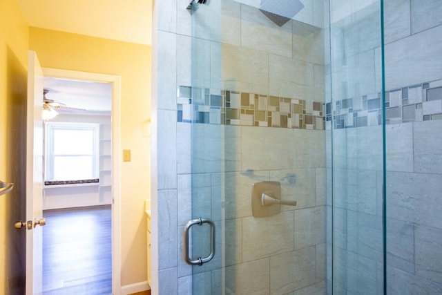 bathroom with a shower stall, a ceiling fan, and baseboards