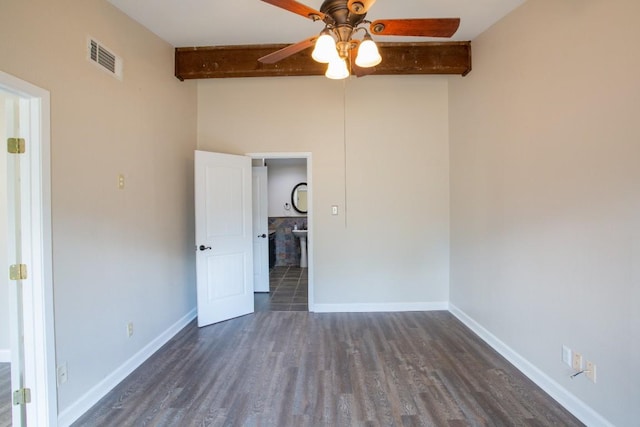 unfurnished bedroom featuring dark wood-style floors, beamed ceiling, baseboards, and visible vents