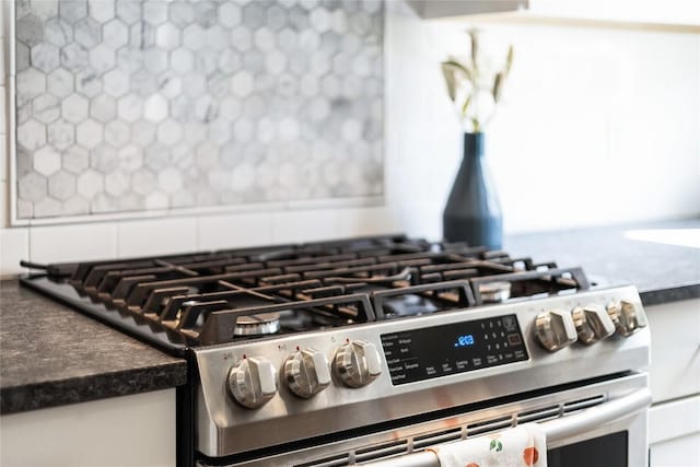 details with dark countertops, tasteful backsplash, and stainless steel gas stove