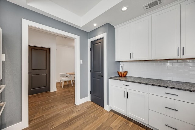 kitchen featuring visible vents, tasteful backsplash, white cabinetry, recessed lighting, and light wood finished floors