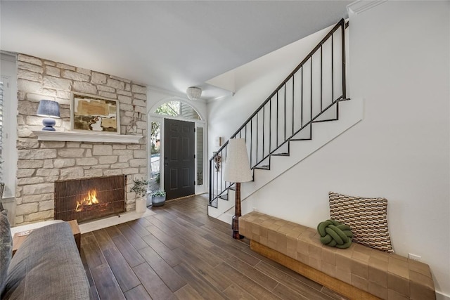 foyer featuring stairs, wood finished floors, and a fireplace