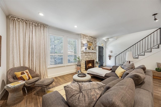 living area featuring baseboards, stairway, recessed lighting, a fireplace, and wood finished floors