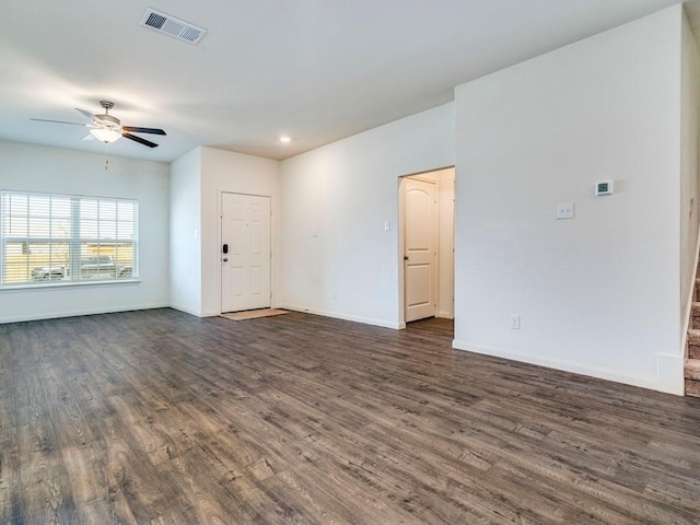 empty room with visible vents, baseboards, dark wood finished floors, and a ceiling fan