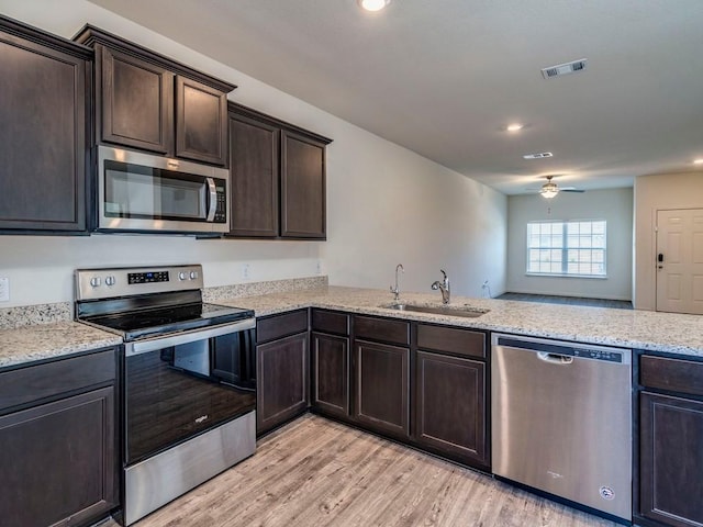 kitchen with a ceiling fan, visible vents, a sink, dark brown cabinetry, and appliances with stainless steel finishes