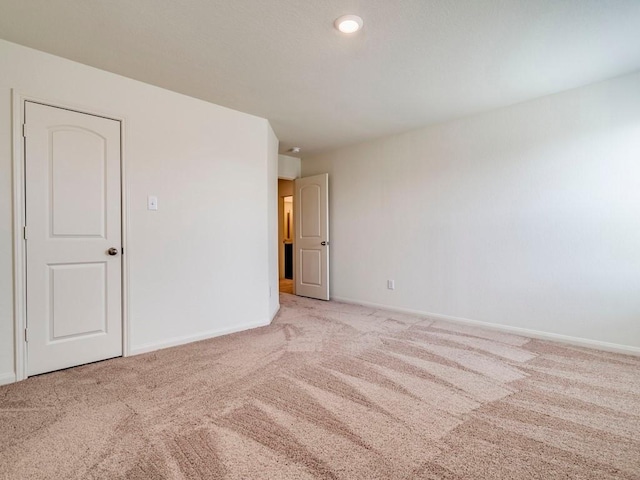 carpeted empty room with baseboards