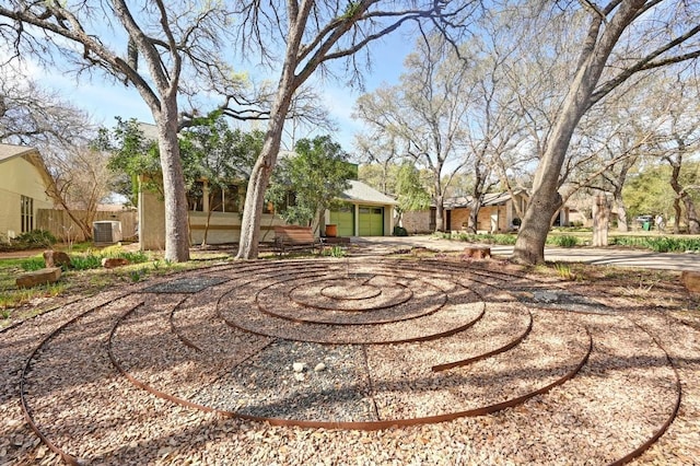 view of yard with a garage and central AC