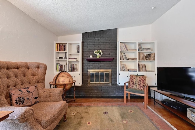 living area with vaulted ceiling, a brick fireplace, built in features, and a textured ceiling