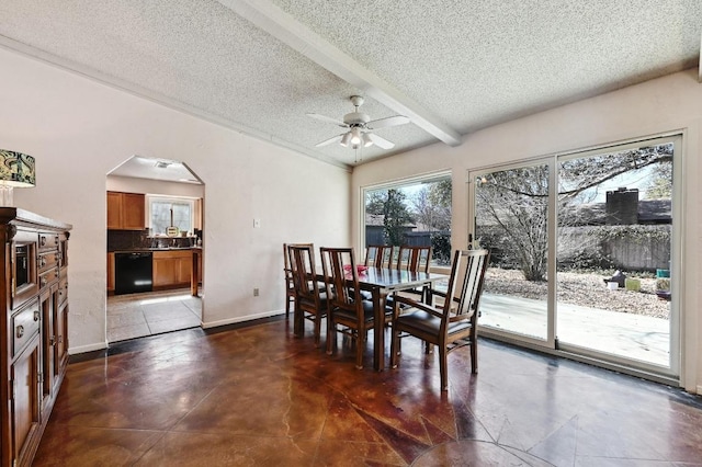 dining room featuring baseboards, concrete floors, arched walkways, ceiling fan, and a textured ceiling