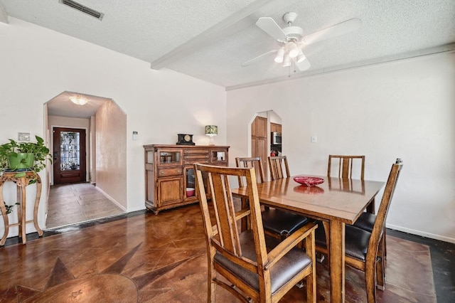 4711 Fieldstone Dr, Austin, TX 78735 - dining area with arched walkways, a textured ceiling, a ceiling fan, and beam ceiling