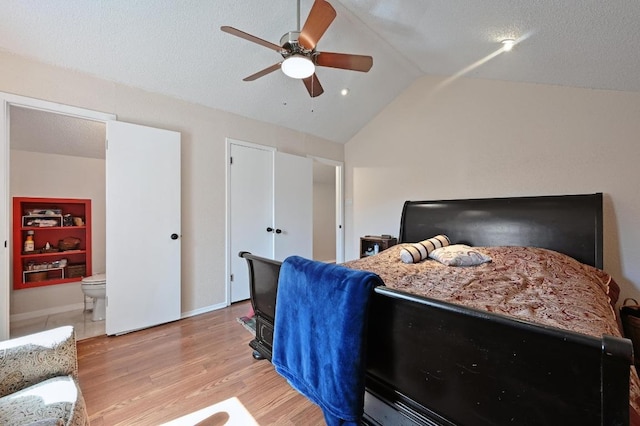 bedroom with light wood-type flooring, lofted ceiling, a textured ceiling, and a ceiling fan