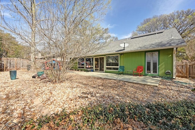 back of house featuring a patio, fence, and roof with shingles