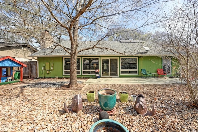 rear view of property featuring a patio area, a chimney, and fence