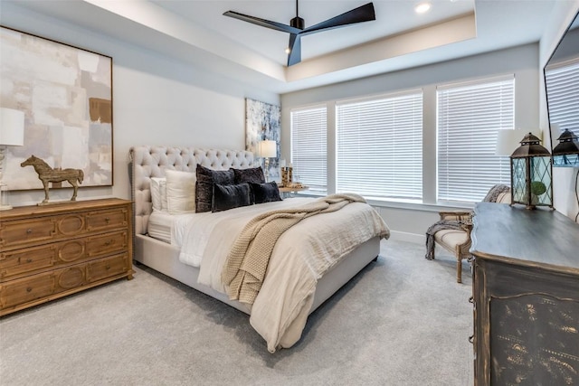 bedroom with carpet flooring, baseboards, a raised ceiling, and ceiling fan