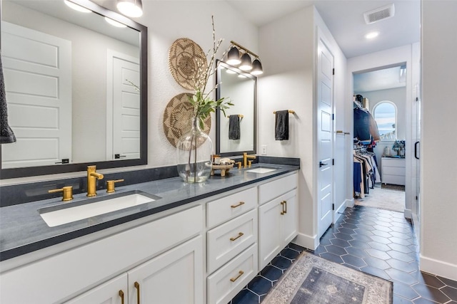 full bathroom with double vanity, visible vents, tile patterned flooring, and a sink